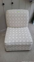 Front view of Ethan Allen armless upholstered chair showing seat and backrest with circular pattern fabric.