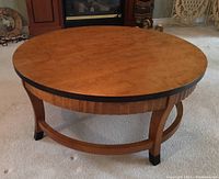 Front angle showing round top, dark stained rim, and circular stretcher base.