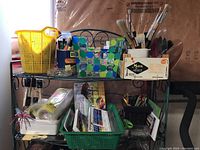 Full view of assembled arts and crafts supplies on wire rack including baskets, brushes, glue, colored pencils and paint sets.