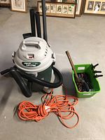 Full view of Shop-Vac QuietPlus and container of hand tools with extension cord coiled in front