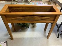 Front view of the solid wood raised planter showing rectangular planter box and leg structure.