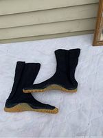 Side profile of black Jika Tabi ninja-style sock shoes showing gum sole and ankle-high legging design.