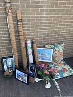 Photo showing bamboo roll-up blinds, framed pictures, floral seat cushion, wicker basket, and flower arrangement