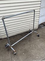 Full view of the metal pipe rolling garment rack showing its height and width with locking casters and pipe joints.