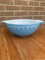 Side view of blue Pyrex mixing bowl with white Calico pattern, showing decorative band and spout.