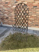 Front view showing the curved trellis back and lower slatted shelf with side scroll details.