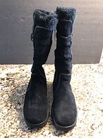 Front view of both black suede tall boots with faux fur inside top collar showing and zipper on inner side.