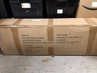 Photo of the shipping box with shipping labels visible, indicating the exercise bike is new and unopened.