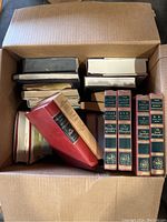 Box containing 25 hardcover books including several by Mark Twain with a set of 5 volumes from The World's Great Thinkers series visible.