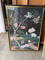 Full view of framed reproduction painting depicting birds on branches and flowers with dark background.