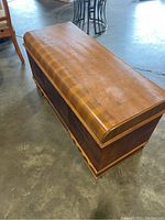 Top angled view of wooden cedar chest showing rounded lid and wood grain.