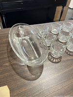 Oval clear glass serving dish and multiple small clear glass cups