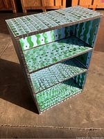 Front angle view of painted bookcase showing interior shelf design and top surface pattern