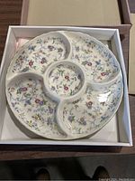 Floral ceramic serving tray showing four divided outer sections and a round center section without lid