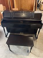 Full front view of the black Weaver spinet piano with matching bench in front.