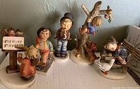 Group photo showing all five vintage Hummel figurines arranged side by side on a flat surface.