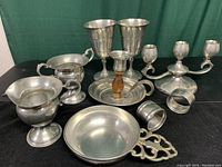 Photo shows all 9 pieces arranged on table: porringer, candle holders, napkin rings, goblets, cream and sugar set