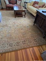 Full view of the muted gold area rug showing position in a living room with furniture around.