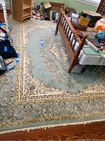 Overhead view of rug under wooden bed and furniture showing full pattern layout