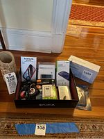 Wide shot of all items arranged on black tray and floor, showing boxes, Popsockets, phone cases, and other accessories.