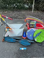 Photo showing Razor scooter, skateboards, penny boards, hula hoops, cones, and jump trainer in white tub