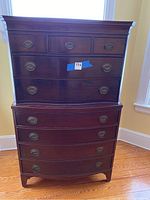 Front view of the tallboy dresser showing nine drawers with antique-style metal pulls and wood finish.