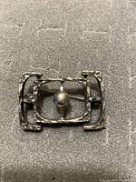 Front view of the silver brutalist style brooch showing geometric design and central sphere.