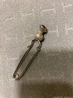 Full view of the kilt pin showing the entire silver thistle with amethyst stone with pin mechanism.