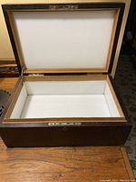 Open vintage wood box showing white interior lining and inside structure
