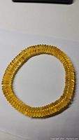 Bracelet laid flat under natural light showing golden translucent amber beads.