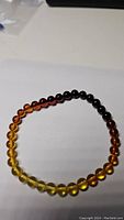 Front view of the amber bracelet showing color gradient from light yellow to dark brown beads.