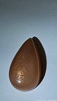 Pear-shaped peach moonstone cabochon showing sparkling inclusions.