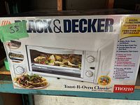 Box of Black And Decker Toast-R-Oven Classic TRO210 toaster oven showing front image and product features.