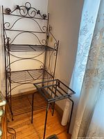 Photo of two metal wire stands, one large multi-shelf with scrollwork and one smaller square stand beside it.