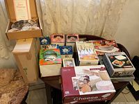 Overview of miscellaneous home decor and kitchen items in original and opened boxes on a table