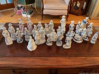 Wide view of all figurines on wooden surface showing grouping and variety