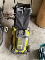 Top-down view of green Ryobi mower with grass bag attached