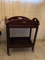 Tea trolley full view showing four caster wheels and removable tray on top with cut out handles