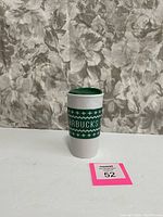 Front view of the 2016 Starbucks Ugly Sweater Mug showing the green knit sweater pattern and 'STARBUCKS' text.