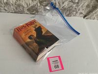 Harry Potter and the Deathly Hallows book sealed in plastic bag with auction lot tag