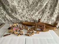 Photo showing the entire wooden Noah's Ark set including ark parts, platform, and all animal and character figures displayed in front.