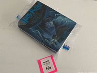 Front view of the hardcover book with original dust jacket in a plastic bag, displaying the title and artwork.