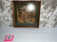 Full view of framed French tapestry depicting a man and woman in vintage clothing in a natural setting.