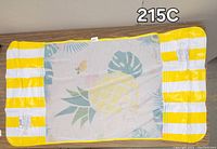 Rectangular inflatable pool float laid flat, showing yellow and white striped edges, and center mesh panel with tropical fruit and leaf design including pineapple.