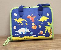 Front side of the soft felt busy board showing dinosaur illustrations and eggs with names