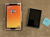 Front view of two tablets; larger one with pearlescent pink case showing 'Welcome to Fire' screen, smaller tablet screen off