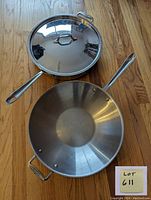 14-inch wok with lid resting on hardwood floor, showing whole set with lot number card