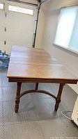 Antique wood dining table without leaves extended, showing the top and carved legs.