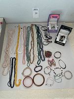 Overhead view of necklaces, bracelets, brooch and watches on table