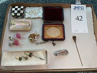 Overview of four small hinged boxes and assorted jewelry including earrings, brooch, tool pendant, tie clip and stickpins